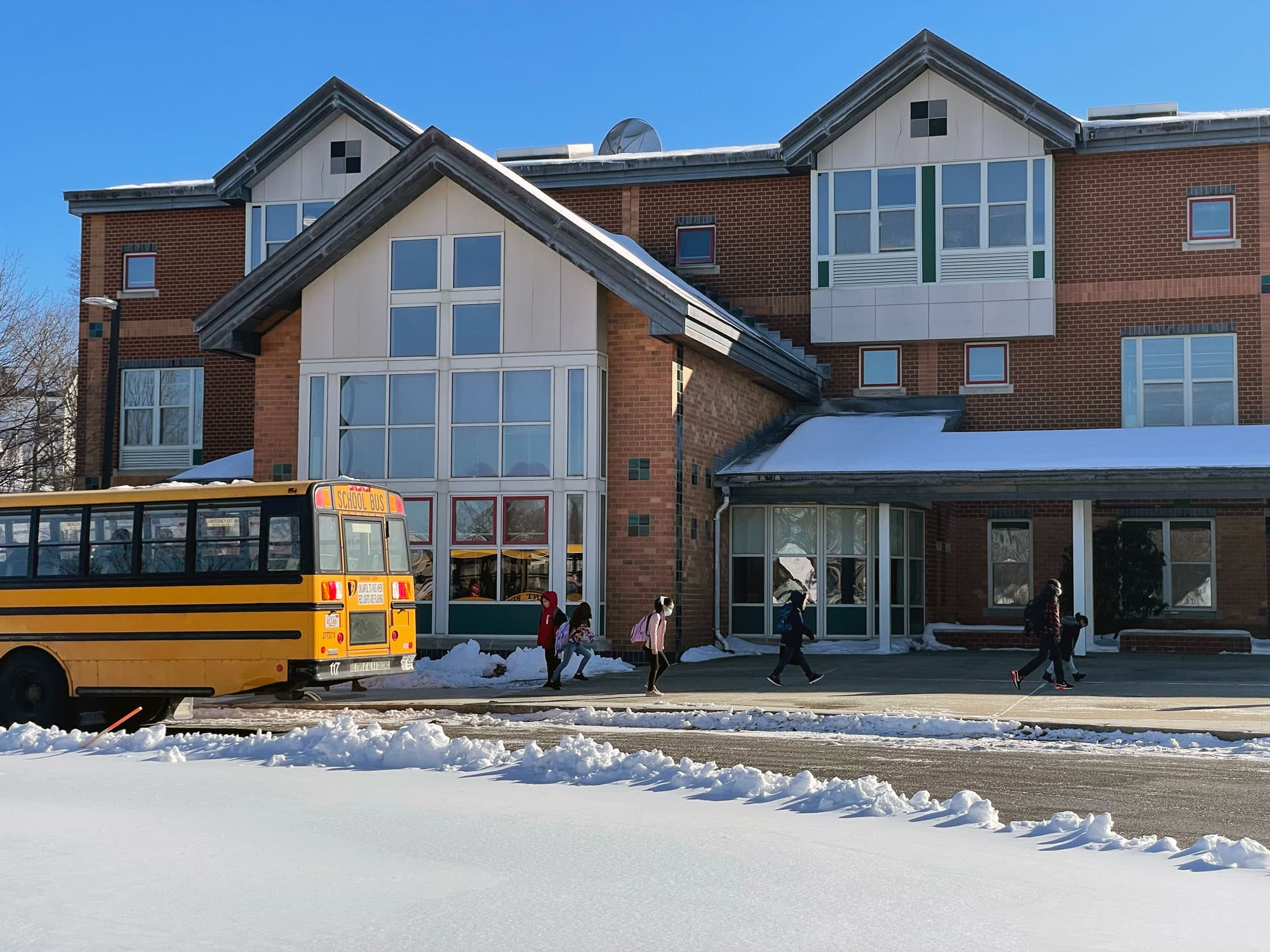 Students disembark from the bus on the first day without mandatory masking in Haverhill schools. (Max Larkin/WBUR)