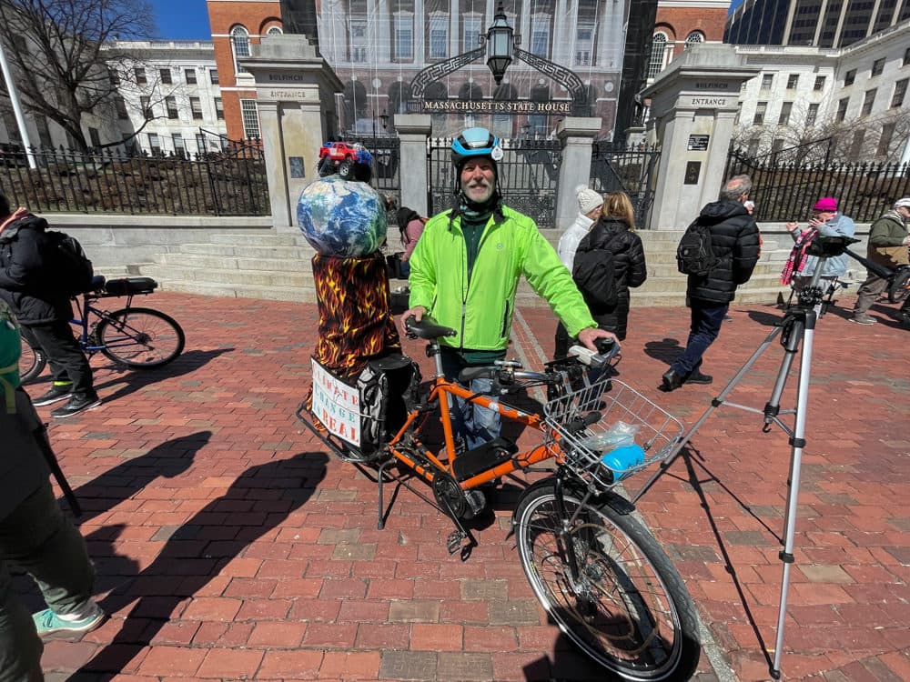 Alan Wright shows off his electric bike after a rally at the State House on March 30, 2022. The photo was taken by Chris Van Buskirk for SHNS.