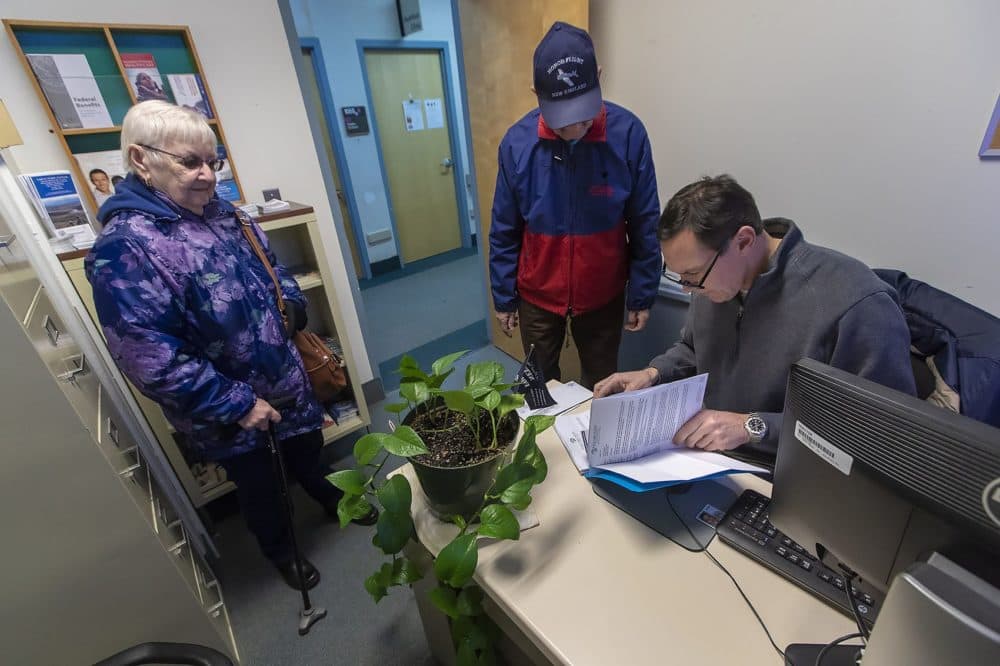 Patient experience coordinator Chris Riga assists veteran Frederick Borowec and his wife Alexandra at the Northampton VA Medical Center, one of the centers at risk of closing under the U.S. Department of Veterans Affairs' plan. (Jesse Costa/WBUR)