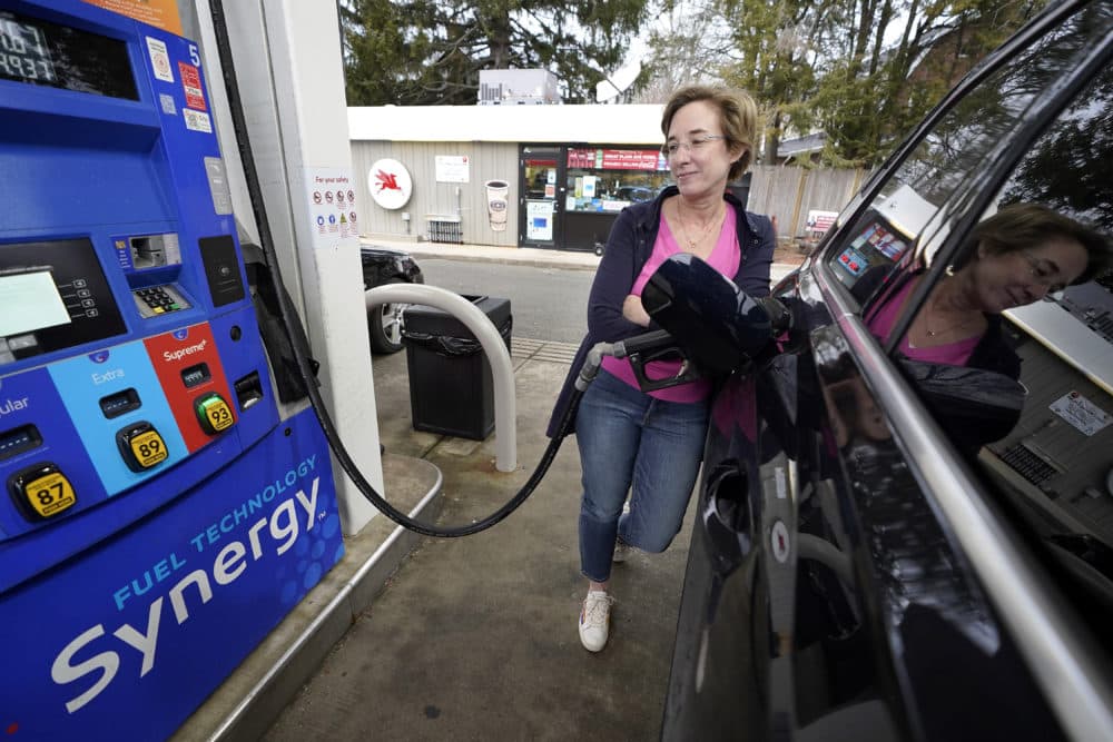 Jennifer Quinn, of Needham, Mass., fills her SUV at a gas station on Monday, March 7, 2022, when the price of regular gasoline broke $4 per gallon on average. (AP Photo/Steven Senne)