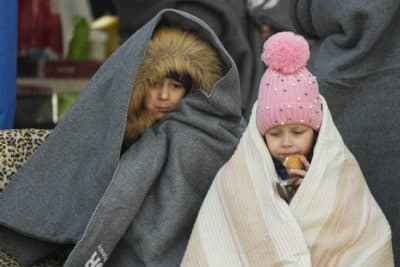 Ukrainian children covered with blankets have a meal after fleeing the war from neighboring Ukraine, at the border crossing in Palanca, Moldova, Thursday, March 10. (Pavel Golovkin/AP)
