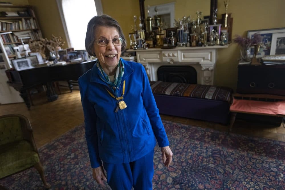 Sara Mae Berman, at her home in Cambridge, Mass., wears a medal she was presented for her Boston Marathon wins in 1969, 1970, and 1971. The Boston Athletic Association began recognizing women racers officially in 1972. (Jesse Costa/WBUR)