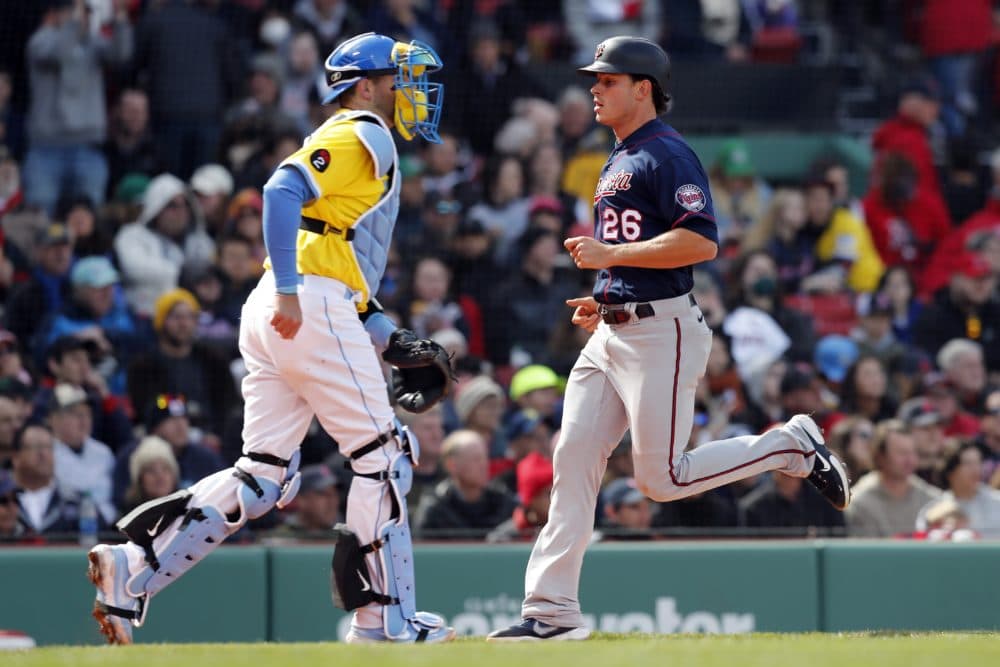 Minnesota Twins' Max Kepler (26) scores in front of Boston Red Sox's Kevin Plawecki on the sacrifice fly by Trevor Larnach during the seventh inning of a baseball game, April 17, 2022, in Boston. (Michael Dwyer/AP)