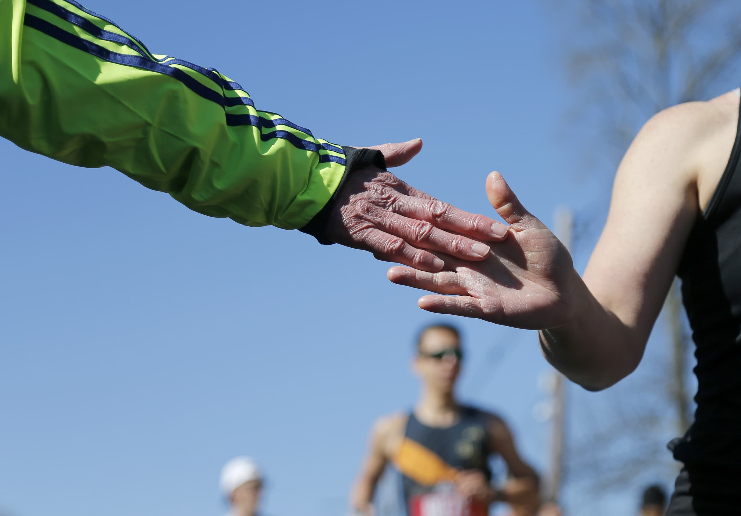 A volunteer offers a high-five to a runner during the 126th Boston Marathon. (Mary Schwalm/AP)