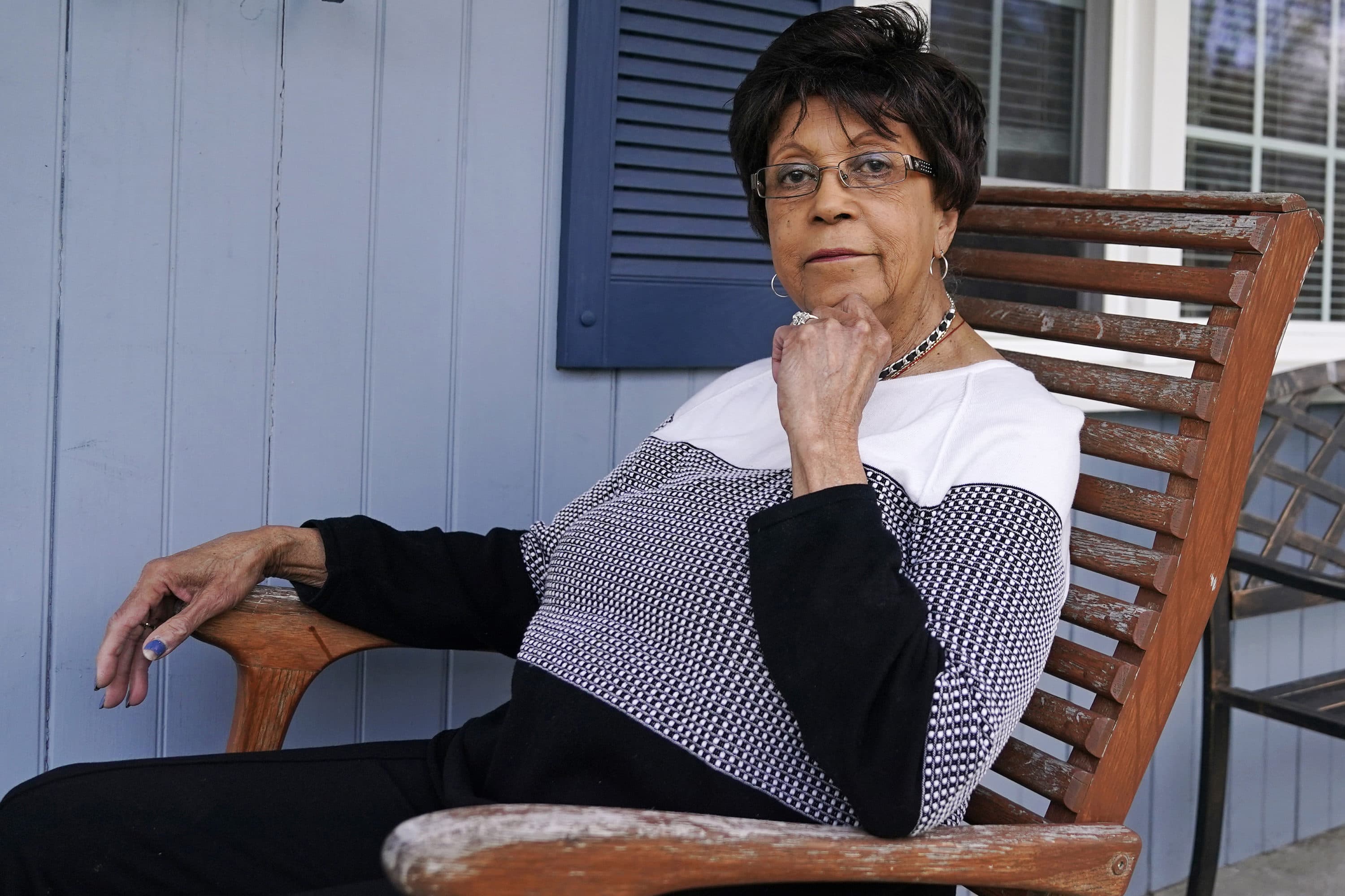 Roberta Wolff, a descendant of Tony, Cuba and Darby Vassall who were enslaved by Harvard benefactors in the institution's first decades, poses on the front porch of her family home, April 27, 2022, in Bellingham, Mass. (Charles Krupa/AP)