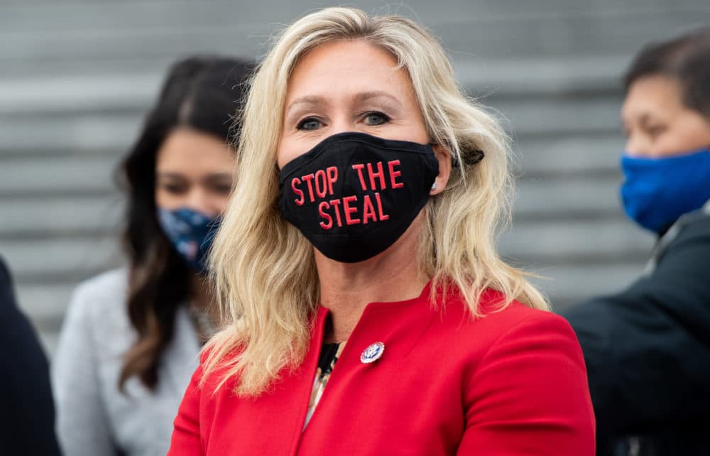 Rep. Marjorie Taylor Greene, Republican of Georgia, holds up a &quot;Stop the Steal&quot; mask while speaking with fellow first-term Republican members of Congress on the steps of the US Capitol in Washington, DC, Jan. 4, 2021. (Saul Loeb/AFP via Getty Images)