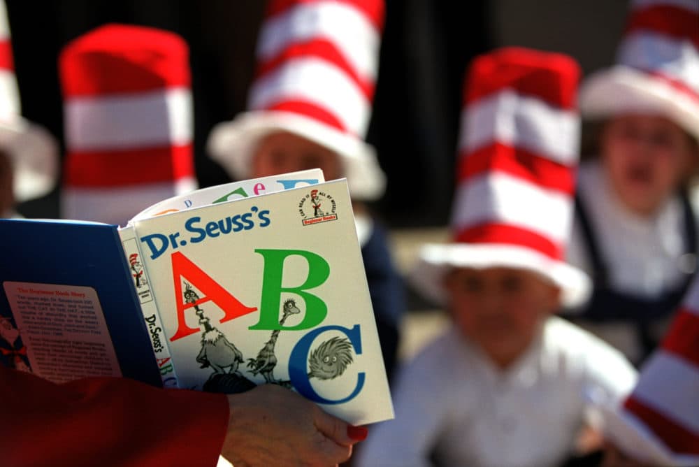 An adult reads to kids from various Dr. Seuss books in honor of Dr. Seuss's birthday, Van Nuys Elementary School.  (David Bohrer/Los Angeles Times via Getty Images)