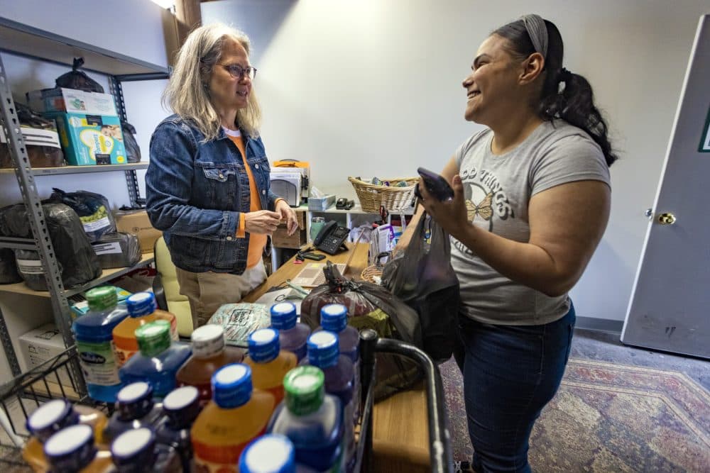 Brenda Torres, right, smiles as she picks up diapers and Pedialyte from Lisa Smith at Neighbors in Need diaper bank and food pantry in Lawrence. (Jesse Costa/WBUR)