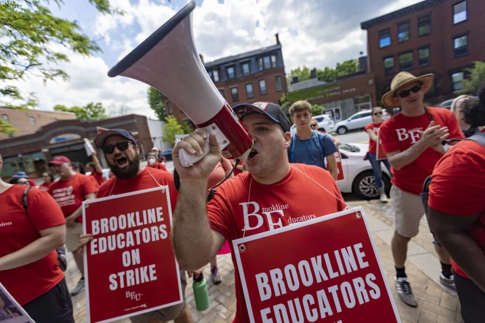 Hundreds of members of the Brookline Educators Union rally outside of Brookline Town Hall on Monday. (Jesse Costa/WBUR)