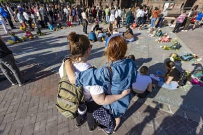 Erin McLaughlin and Katie McEwan stand arm-in-arm as they participate at the memorial in Copley Square for the victims of the school shooting at Robb Elementary School in Uvalde, Texas. (Jesse Costa/WBUR)