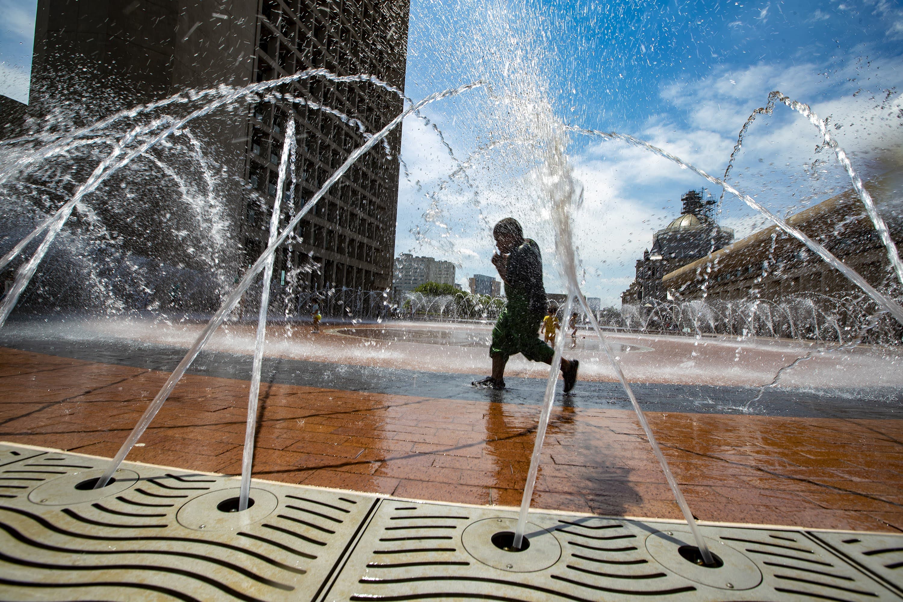A child runs through the fountain at the Christian Science Plaza in Boston in the summer of 2021. (Jesse Costa/WBUR)