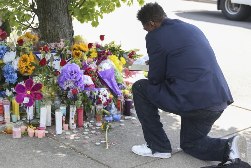 A man reads scripture at the site of a memorial honoring the victims of Saturday's shooting on Sunday, May 15, 2022, in Buffalo, N.Y. (Joshua Bessex/AP)