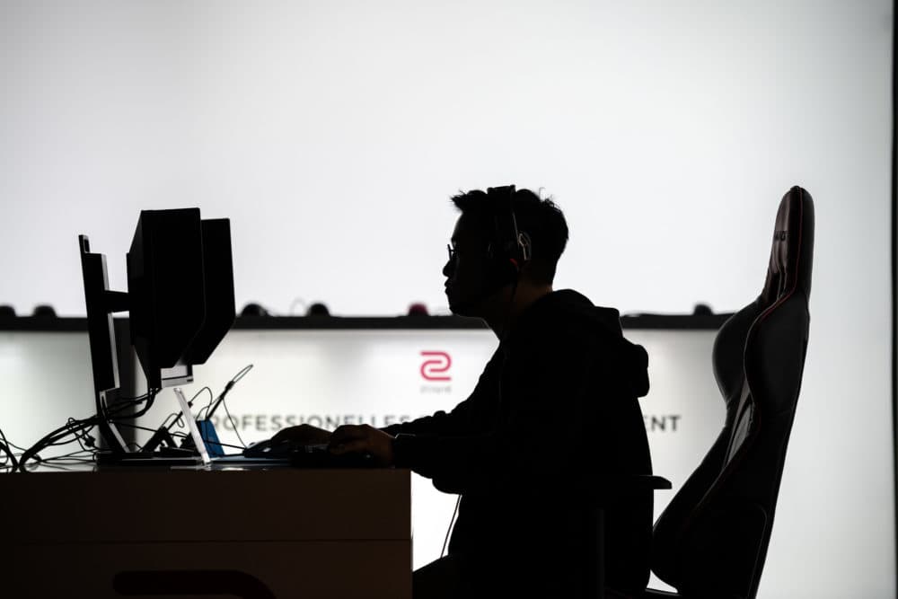 A man sits at a computer monitor to play a video game. (Jens Schlueter/Getty Images)