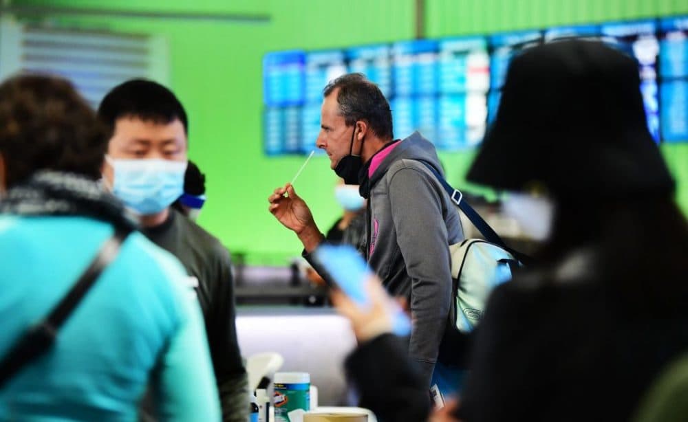 A man swabs his nose at a rapid Covid-19 testing site in the international terminal at Los Angeles International Airport on December 3, 2021. (Frederic J. Brown/AFP via Getty Images)