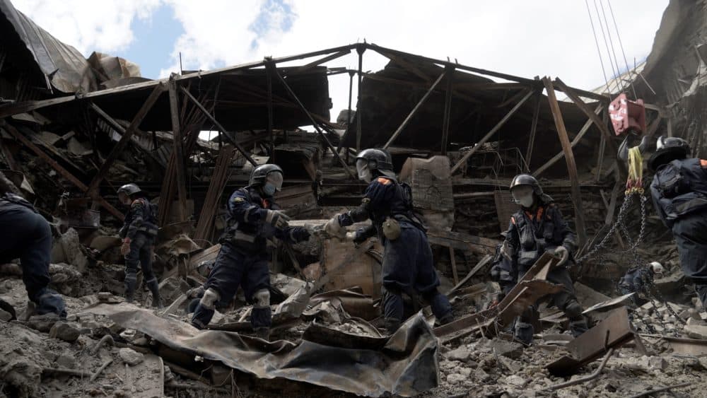 Russian Emergencies personnel clear debris in the partially destroyed Mariupol drama theatre in the city of Mariupol on May 10, 2022, amid the ongoing Russian military action in Ukraine. (Stringer/AFP via Getty Images)