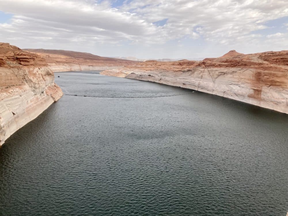 A view from the top of Glen Canyon Dam where the historically low water levels are visible, about 180 feet lower than their peak. (Peter O'Dowd/Here & Now)