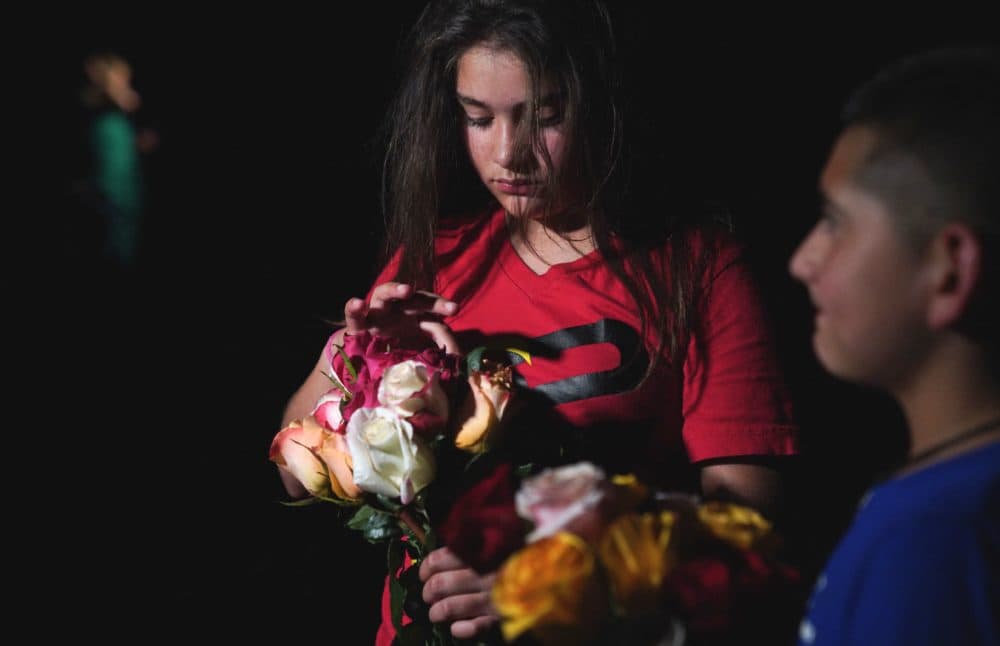 A young girl holds flowers outside the Willie de Leon Civic Center where people gather to mourn in Uvalde, Texas, May 24, 2022. (Photo by Allison Dinner/AFP via Getty Images)