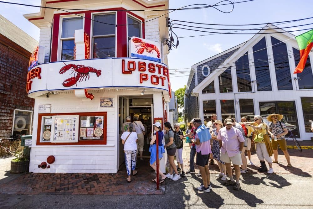 A line of tourists enters the Lobster Pot in Provincetown just as the restaurant opens its doors for the day. Big crowds are expected in town for the July 4th weekend. (Jesse Costa/WBUR)