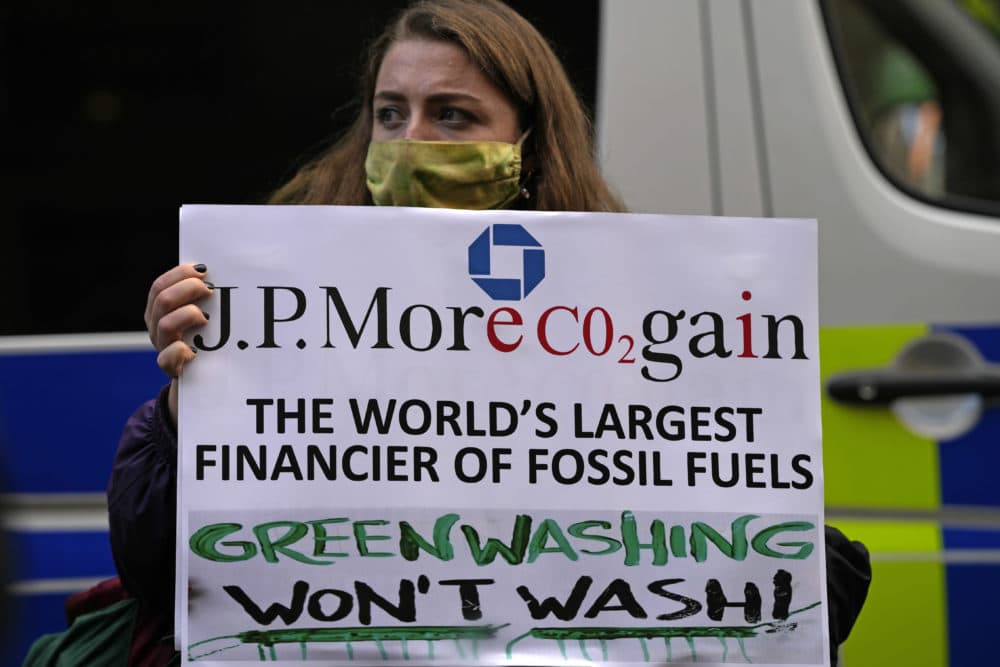 Extension Rebellion activists protest in front of JP Morgan premises as they take part in a demonstration against 'Greenwashing' (an attempt to make people believe that your company or government is doing more to protect the environment than it really is) near the COP26 U.N. Climate Summit in Glasgow, Scotland, Wednesday, Nov. 3, 2021. (Alastair Grant/AP)