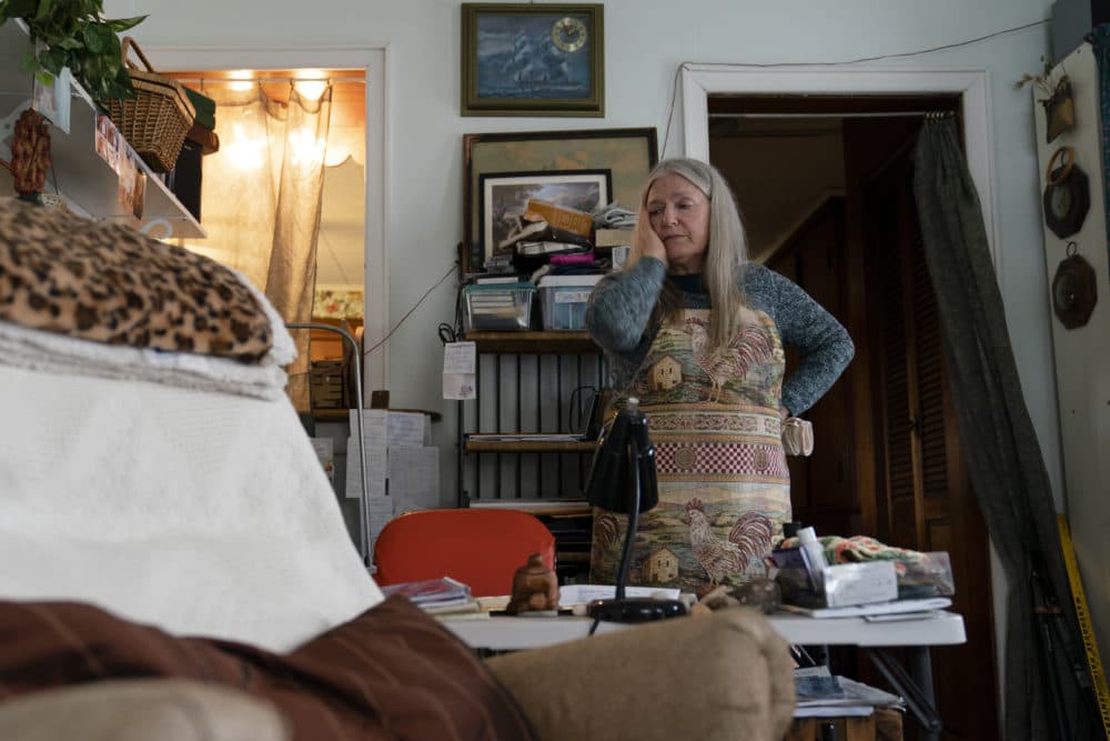 Nancy Rose, who contracted COVID-19 in 2021 and continues to exhibit long-haul symptoms including brain fog and memory difficulties, pauses while organizing her desk space, Tuesday, Jan. 25, 2022, in Port Jefferson, N.Y. (John Minchillo/AP)