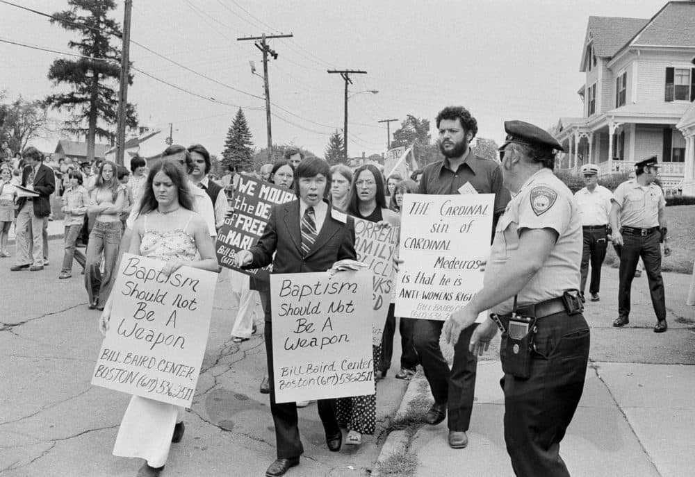 Birth control advocate Bill Baird, center, and Carol Morreale, left, as they led a demonstration outside the Immaculate Conception Church, Aug. 18, 1974 in Marlboro, Mass., protesting the denial of the baptismal sacrament to 3-month-old Nathaniel Morreale.(AP)