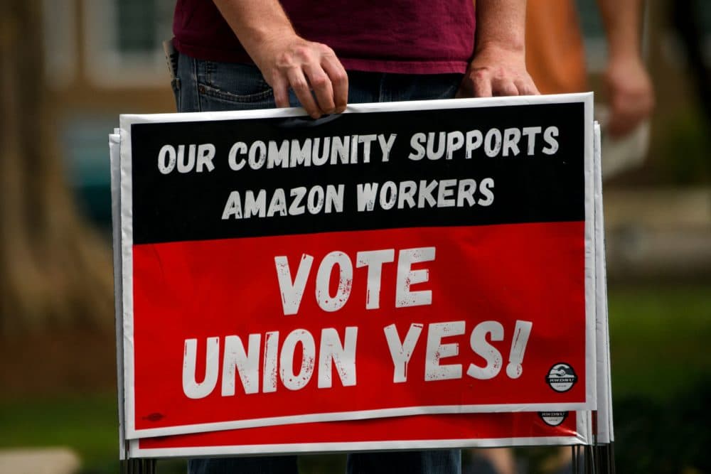 A person holds &quot;Vote Union Yes!&quot; signs during a protest in solidarity with Black Lives Matter, Stop Asian Hate and the unionization of Amazon.com, Inc. fulfillment center workers at Kelly Ingram Park on March 27, 2021 in Birmingham, Alabama. (Patrick T. FALLON/AFP via Getty Images)