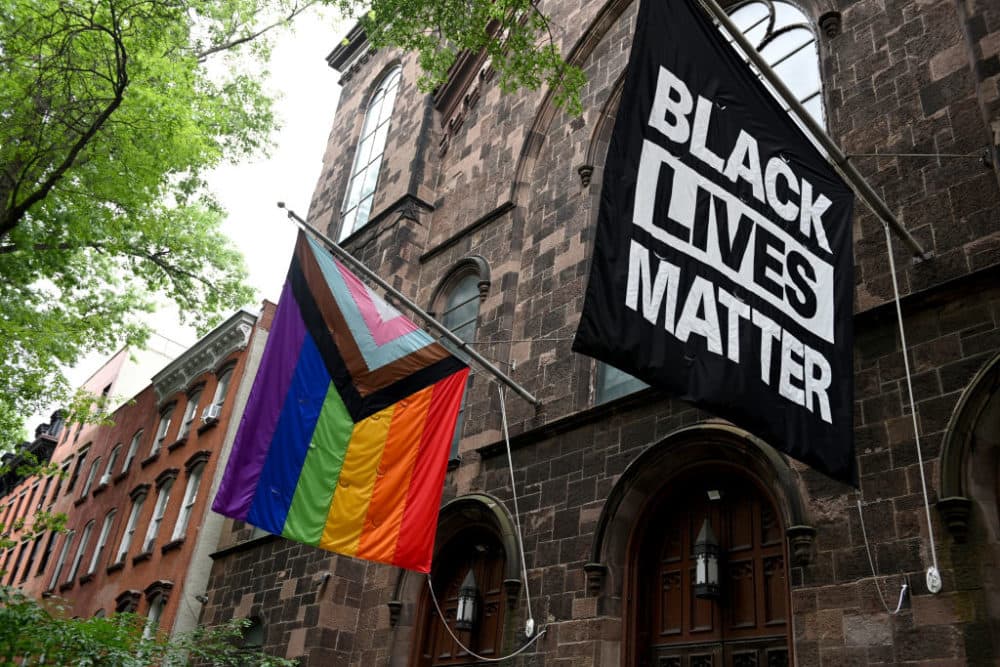 A progress pride flag and a Black Lives Matter flag are displayed outside a church on June 13, 2021 in the Brooklyn Borough of New York City. (Alexi Rosenfeld/Getty Images)