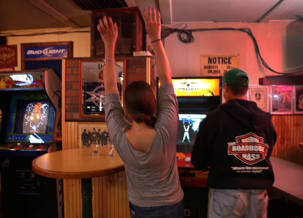 MARSHFIELD, MA - MAY 22: The coin-operated arcade and video game ban is over in Marshfield. Arms up for the winner is Michelle Poirier, left, who played the game with Robbie DiCciaro, right, at the Roadhouse in Marhsfield. (Photo by David L. Ryan/The Boston Globe via Getty Images)
