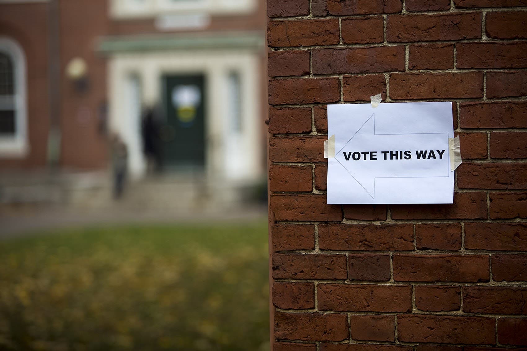 A sign posted on a wall showing Harvard students the direction to go to vote. (Jesse Costa/WBUR)