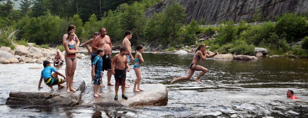 People keep cool by swimming in the water at the Lower Falls of the Swift River, Tuesday, July 16, 2013 in Albany, N.H. A weeklong heat wave continues to bear down on much of the region. (AP Photo/Jim Cole)