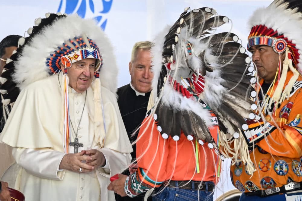 Pope Francis wears a headdress presented to him by Indigenous leaders during a meeting at Muskwa Park in Maskwacis, Alberta, Canada, on July 25, 2022. (Patrick T. Fallon/AFP via Getty Images)