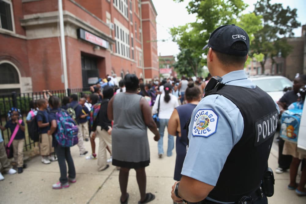 Chicago Probationary Police officer Juan Soto watches as students leave Laura Ward Elementary school. (Scott Olson/Getty Images)