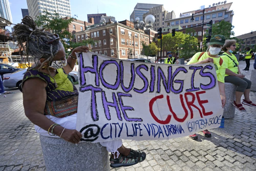 In this June 9, 2021, photo, people hold a sign during a rally in Boston protesting housing eviction. (Elise Amendola/AP)