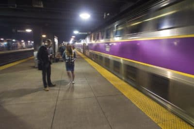 Commuters prepare to board an MBTA Commuter Rail train as it arrives at Back Bay Station. (Jesse Costa/WBUR)