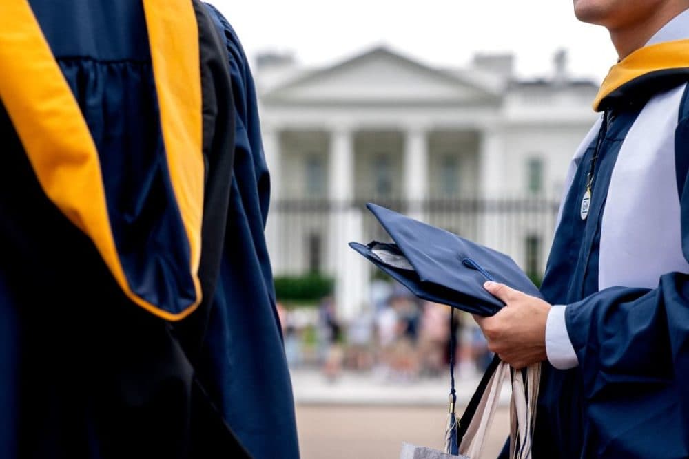 Students from George Washington University wear their graduation gowns outside of the White House in Washington, DC, on May 18, 2022. (Stefani Reynolds /AFP via Getty Images)