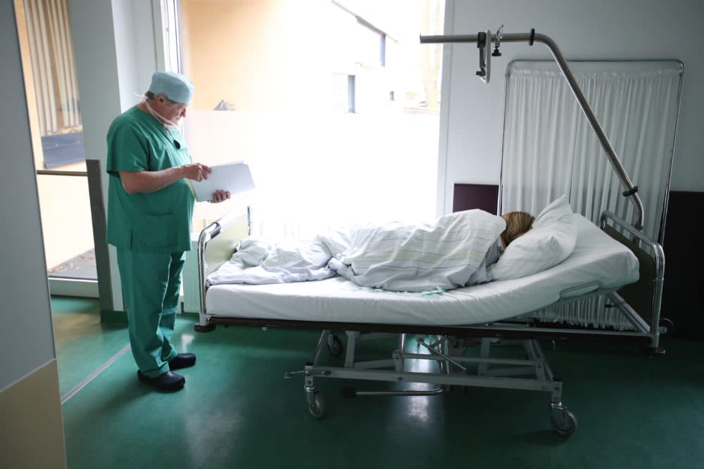 A doctor checks the documents of a young woman from Poland awaking from anesthesia after she underwent an abortion. (Sean Gallup/Getty Images)