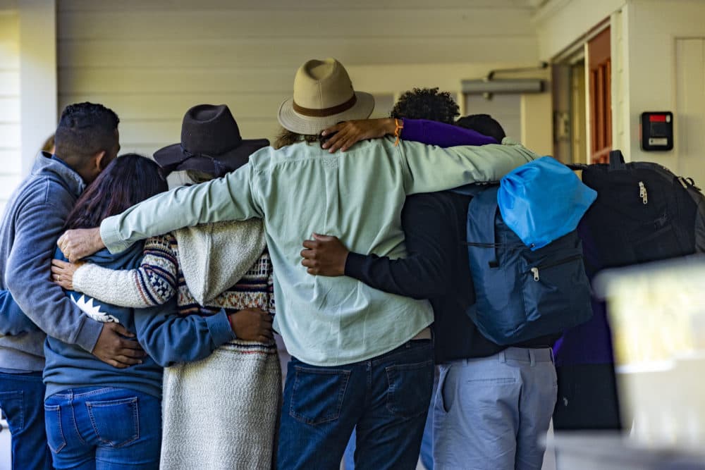 Immigrants and volunteers are arm-in-arm in a huddle leaving St. Andrews Parish House in Edgartown. (Jesse Costa/WBUR)