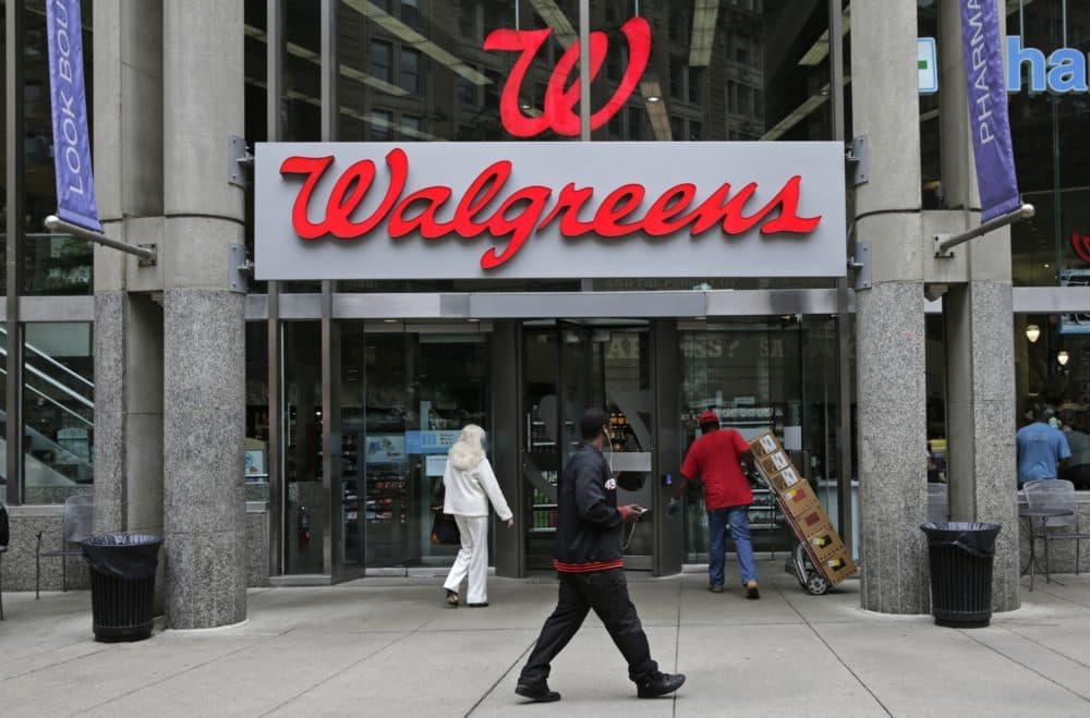 People walk in to a Walgreens retail store in Boston. (Charles Krupa/AP)