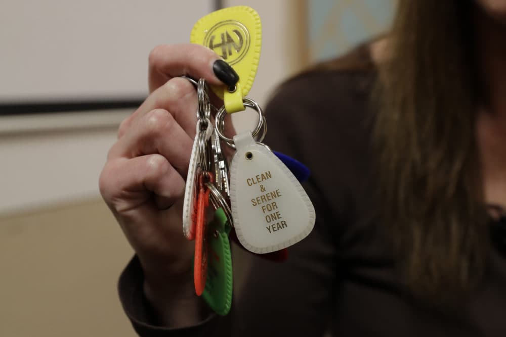 A person holds key fobs that mark her days of sobriety and recovery from using drugs. (Ted S. Warren/AP)