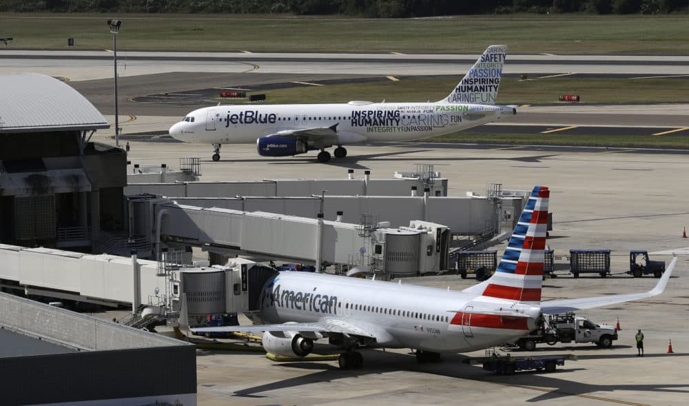A JetBlue Airbus A320 taxis to a gate, Oct. 26, 2016, after landing, as an American Airlines jet is seen parked at its gate at Tampa International Airport (Chris O'Meara/AP File)