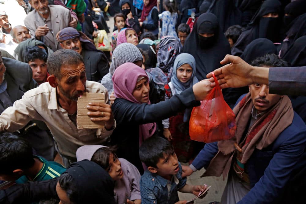 Yemeni people, from families who were affected by the war and blockade, flock to receive free lunch meals, provided by a charitable kitchen at Mseek area on June 29, 2021 in Sana'a, Yemen.  (Mohammed Hamoud/Getty Images)