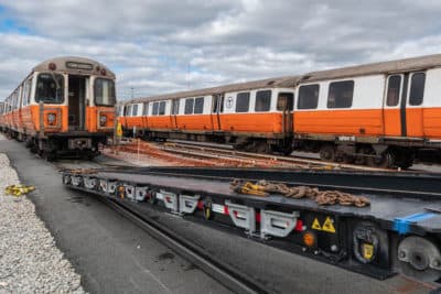 An old Orange Line car is loaded onto a flatbed trailer in Wellington Yard to be scrapped. (MBTA)