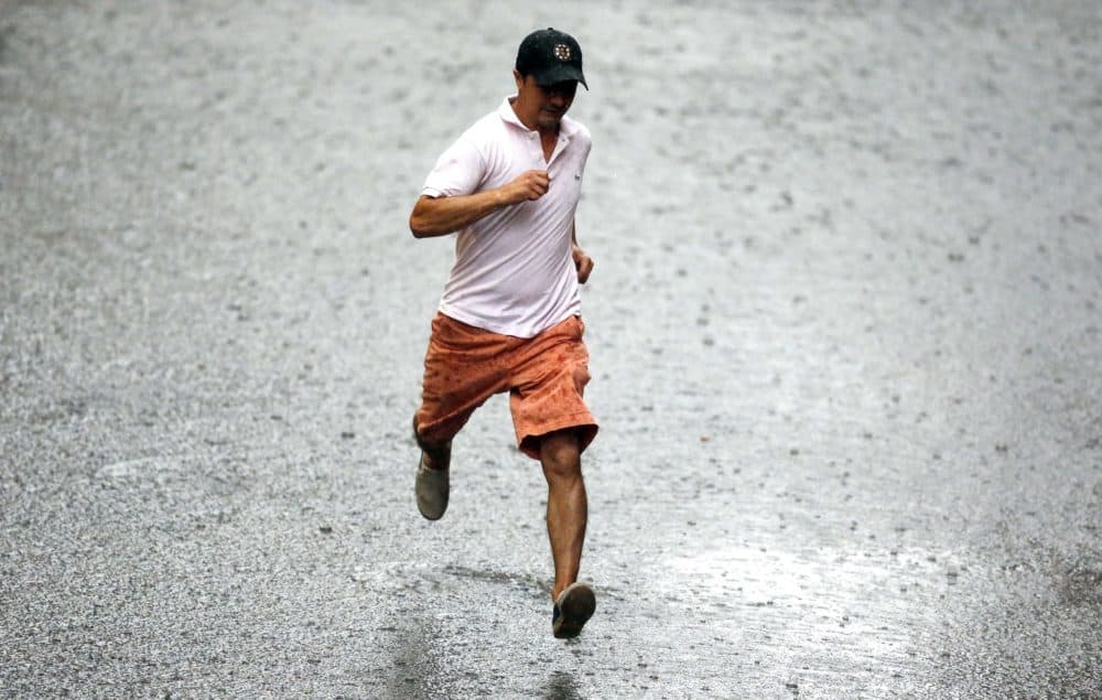 A pedestrian runs through heavy rain in Boston. (Michael Dwyer/AP)