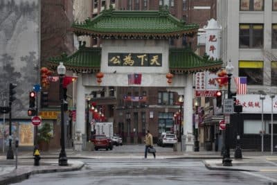 A pedestrian crosses the street at the entrance to Chinatown, April 24, 2020, in Boston. (Michael Dwyer/AP)