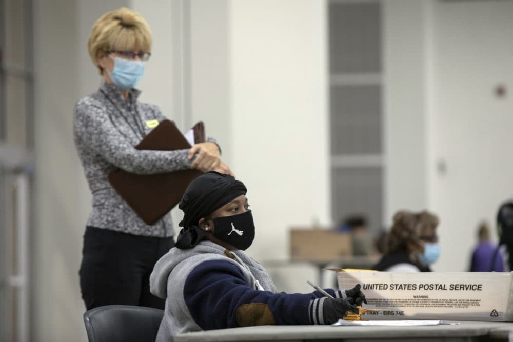 A poll watcher waits as a worker with the Detroit Department of Elections helps process absentee ballots at the Central Counting Board in the TCF Center on Nov. 4, 2020 in Detroit, Michigan. (Elaine Cromie/Getty Images)