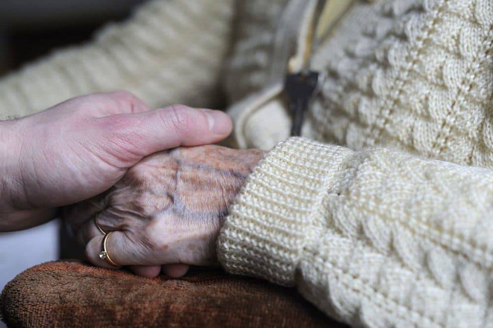 A woman, suffering from Alzheimer's desease, holds the hand of a relative on March 18, 2011 in a retirement house in Angervilliers, eastern France. (Sebastien Bozon/AFP via Getty Images)