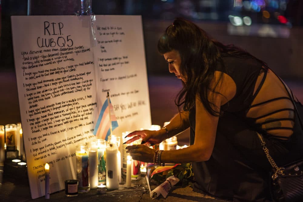 People light up candles at a makeshift memorial for the victims of Saturday's fatal shooting at Club Q in Colorado Springs, Colo., outside Rocco's WeHo in West Hollywood, Calif., Sunday, Nov. 20, 2022. (AP Photo/Damian Dovarganes)
