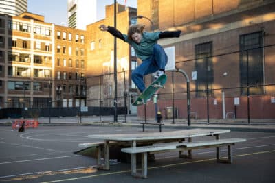 Skateboarder Larkin Tanner, a BU student from Hull, flies over a table at Reggie Wong Park. (Robin Lubbock/WBUR)