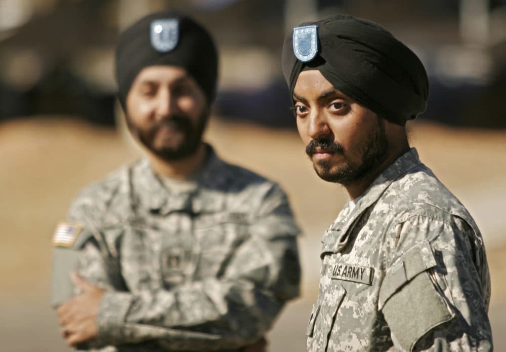 Capt. Kamal Kalsi, left, one of two other Sikh officers serving in the U.S. Army, looks on as Spc. Simran Lamba, front, the first enlisted soldier to be granted a religious accommodation for his Sikh articles of faith since 1984, speaks to members of the media following his basic training graduation. (Brett Flashnick/AP)