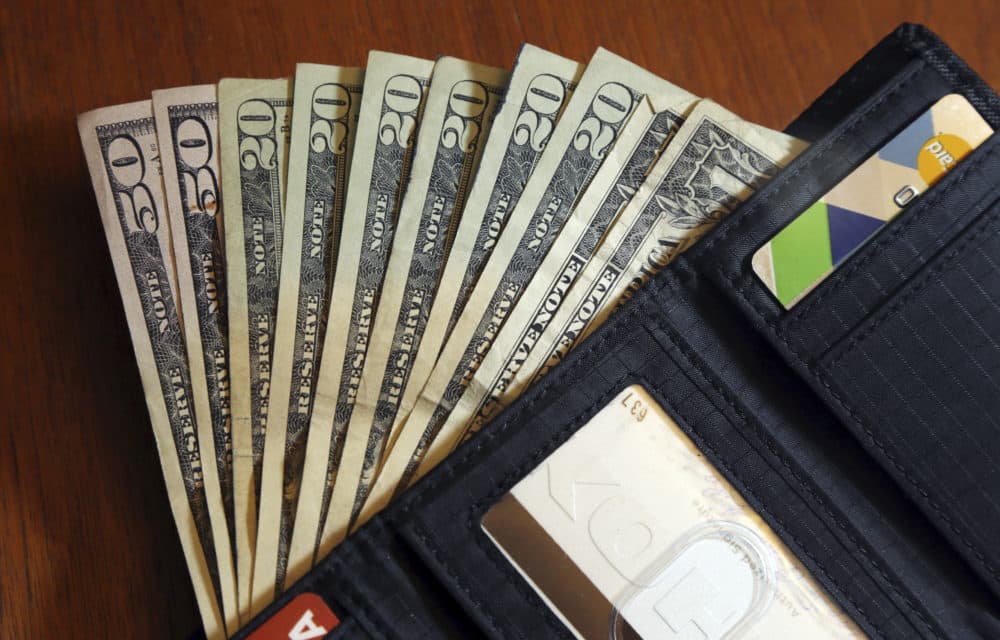 Cash is fanned out from a wallet. (Elise Amendola/AP)